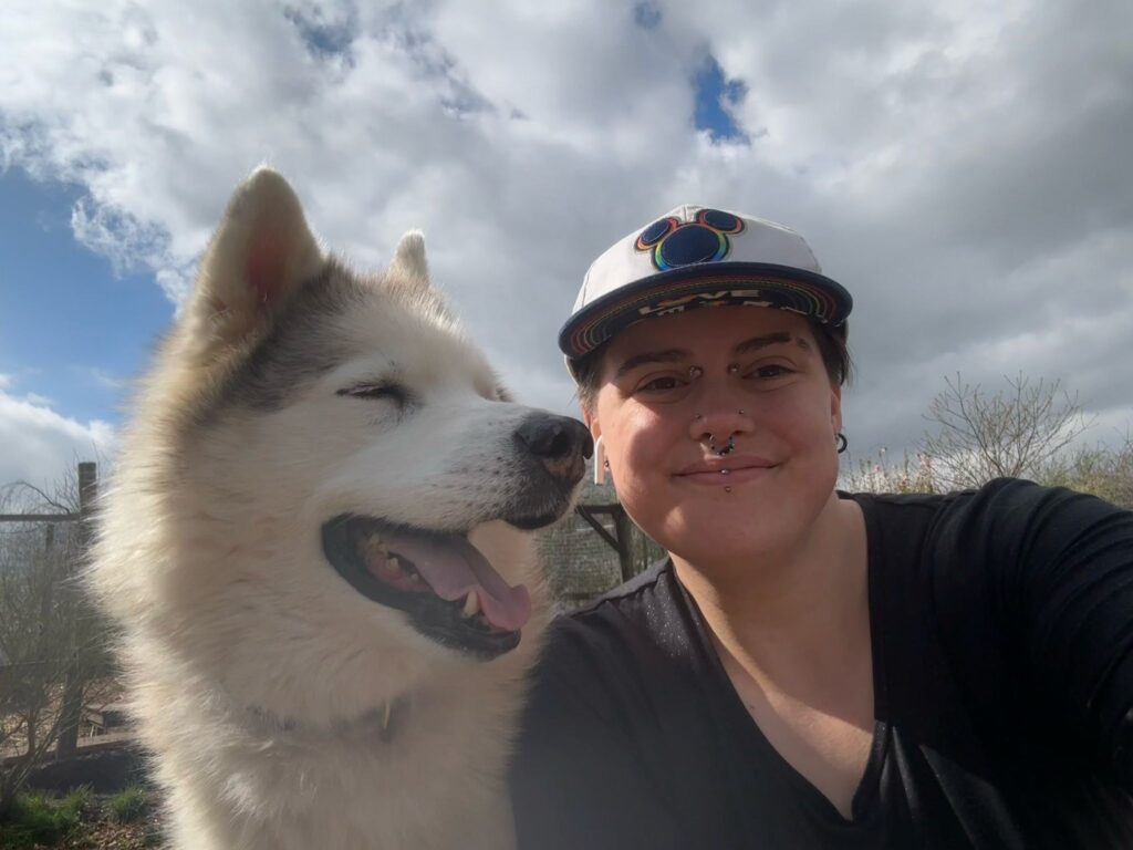 Volunteer taking a selfie with a happy husky, both smiling