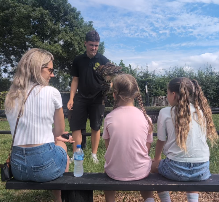 Family at a picnic bench with a member of the Eagle Heights team